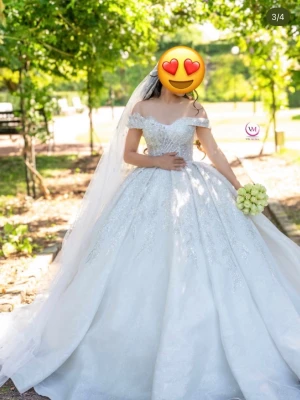 Vit prinsessklänning med glitter - Magisk vit långklänning i prinsessmodell med offshoulder och glittriga detaljer. Klänningen har en vid kjol, spetsdetaljer och vacker släp. Perfekt för dig som vill känna dig som en drottning. Materialet är troligtvis polyester eller liknande och klänningen har en romantisk känsla. Använt endast en gång på min dag. 