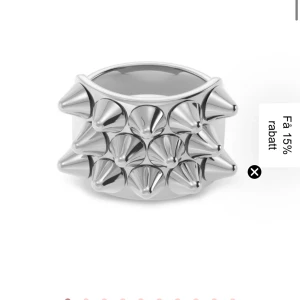 Edblad ring med nitar - Cool ring i blankt silverfärgat metallmaterial med flera spetsiga nitar runt hela ringen. Statement-accessoar som ger en edgy vibe till din stil. Perfekt för dig som gillar att sticka ut och vill ha något unikt i smyckeslådan.
