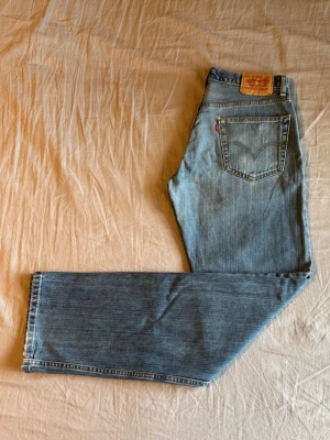 Levi's 505 ljusblå - Klassiska ljusblå jeans från Levi's med rak passform. Storlek: W32 L34. Måtten: Midja - 40 cm Längd - 111 cm Innerbenslängd - 84 cm Fotöppning - 21 cm Lår - 30 cm
