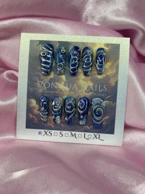 DeepSea (XS);Medium Ballerina - Unika handgjorda press-on naglar i djupblå cateye färg med handmålade silverfärgade swirl-mönster och små dekorationer. Designen är handgjord och varje nagel har olika detaljer med stenar och metallic 3D nailart för en konstnärlig look. Finns i XS: 14 mm, 11 mm, 11,5 mm, 10 mm, 8 mm 