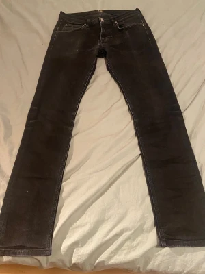 Svarta jeans från Lee - Säljer ett par svarta jeans från Lee med klassisk femficksdesign. Jeansen har en smal passform och är tillverkade i ett mjukt denimtyg som sitter snyggt. Perfekta för dig som gillar en stilren och enkel look.