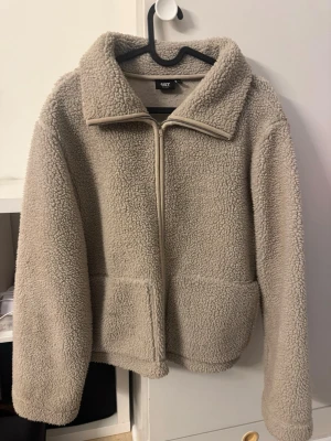 Beige teddyjacka med dragkedja - Mysig beige teddyjacka från lager 157 med hög krage och dragkedja framtill.  