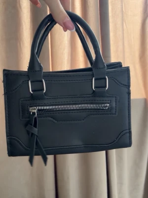 Handväska  - Söt liten handväska i svart med fack 