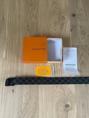 Hm rutigt bälte i skinn - Snyggt svart och grått bälte från hm med klassiskt rutigt mönster. Bältet är gjort i skinn och har en stilren design med diskret hm-logga. Perfekt accessoar för att lyfta din outfit.