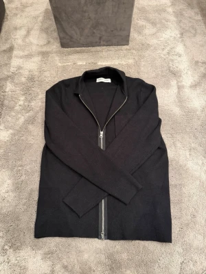 Svart ziptröja från Samsøe Samsøe - Snygg svart ziptröja med krage från Samsøe Samsøe med hel dragkedja framtill. Tröjan är aldrig använd och i toppen skick!