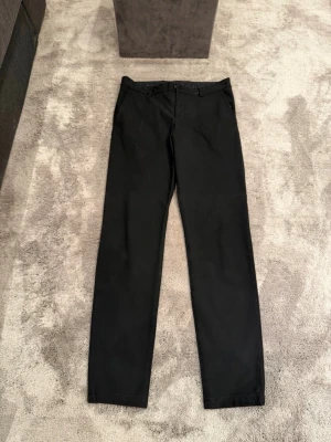 Svarta kostymbyxor/Chinos från Selected/Homme - Svarta kostymbyxor från Selected Homme. Materialet är mjukt, lite chinos känsla på dem. Finns 2 st par om man vill köpa båda för ett bra bundle pris! Storleken är 31/34