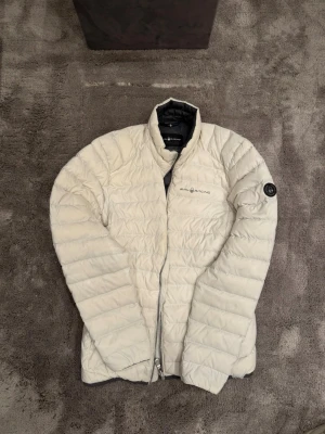 Vit dunjacka från Sail Racing - Snygg vit dunjacka från Sail Racing med quiltad design. Varan är varsamt använd och i väldigt gott skick!