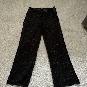 Svarta vida spetsbyxor - Säljer ett par svarta byxor i genomskinlig spets med vida ben. Passar till vilket tillfälle som helst, man kan både klä upp och klä ner dem! Jättebra skick, pris kan diskuteras 