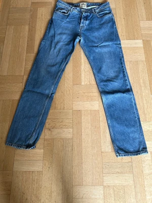 Blå raka jeans från Morris - Klassiska blå jeans från Morris med rak passform och fem fickor. Jeansen har normal midja och är gjorda i slitstarkt denimtyg. Perfekta för en avslappnad och tidlös stil. Använd flitigt men funkar fint ändå. Stolek 33/34.