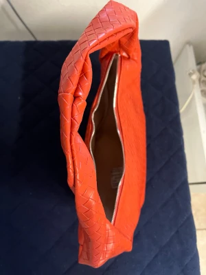 Röd/orange handväska i skinn - Säljer ny röd/orange handvätska som aldrig varit använd utan bara legat runt dock ingen prislapp kvar!