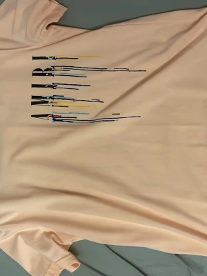 Ljusrosa AMIRI t-shirt med tryck - Säljer en ljusrosa t-shirt från AMIRI med färgstarkt tryck och droppande färgeffekt både fram och bak. T-shirten har korta ärmar och en normal passform. Perfekt för dig som vill sticka ut med en unik och trendig look.