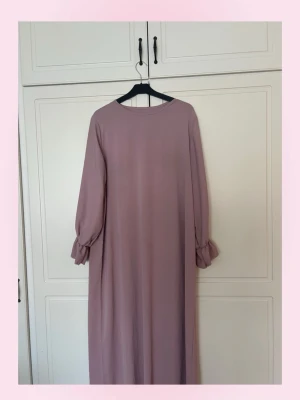 (Abaya)Lång rosa klänning med volangärm - 💕Abaya💕Långklänning i en rosa färg med rund halsringning och långa ärmar som avslutas med volangdetalj vid handlederna. Klänningen har en rak och loose passform, perfekt för en avslappnad men ändå stilren look. Materialet känns lätt och flowy. Passar i storlekar S-L eftersom den är gjord på ett sätt att den ska sitta löst 💞Har fler abayas om du kollar in i min profil