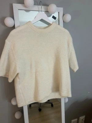 Stickad tröja - Jag säljer ”KNITTED TOP” från Gina tricot som är använd 1 gång. Det är en kortärmad stickad tröja med rund halsringning.  På bilden ser den bredare ut än vad den är! Ordinarie pris är 300kr💕