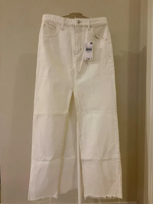 Vit lång jeanskjol - Vit lång jeanskjol med slits fram från Mango i storlek XXS. Har aldrig kommit till användning.