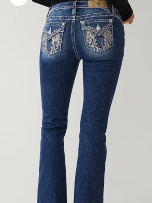 Blå bootcut jeans från Miss Me - Snygga blå bootcut jeans från Miss Me med coola broderade detaljer och nitar på bakfickorna. Jeansen har klassisk femficksdesign och är tillverkade i stretchig denim för en bekväm passform. Nypris är 2300kr och dom är använda 2gr då jag ej tycker passformen passar mig🩷