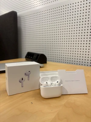 Apple AirPods 3  med laddningsetui - Säljer ett par vita Apple AirPods med trådlöst laddningsetui. Snygg och stilren design i blank plast, perfekt för dig som vill ha smidiga hörlurar till mobilen. Kommer med originalförpackning och tillbehör.