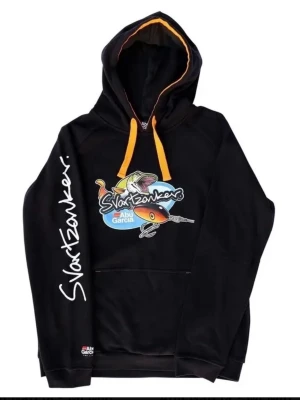Svart Svartzonker x Abu Garcia hoodie - Svart hoodie med färgglad Svartzonker x Abu Garcia-grafik på bröstet och tryck på ena ärmen. Orange snören i huvan och kontrastfärgad insida. Stor känguruficka framtill och liten Abu Garcia-logga nedtill. Perfekt för dig som gillar fiske och streetwear.