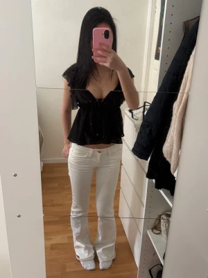 Vita bootcut jeans med låg midja - Supersnygga vita bootcut jeans med guld detaljer från Cheap Monday!! Stl 26/32, använda ett par fåtal gånger. Skriv om du har några frågor, kolla min profil för annat fint!! 💝