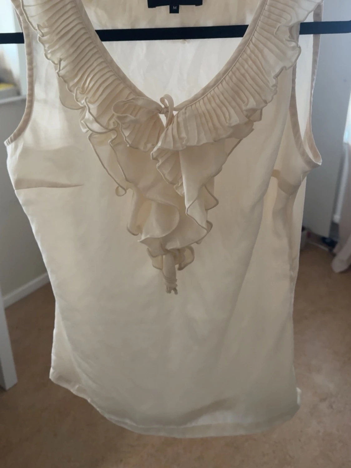 Beige ärmlös blus med volang
