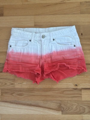 Dip dye shorts i vitt och rött HM - Snygga shorts med dip dye-effekt i vitt och rött. Modellen har fransig kant nertill och justerbar midja. Perfekta till sommaren💕