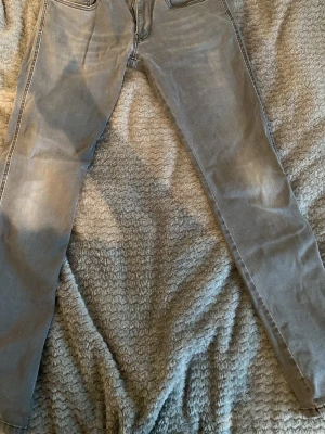 Grå Replay jeans - Snygga grå slim fit jeans med klassisk femficksdesign och normal midja. Jeansen har en något tvättad look och raka ben. Perfekta för en stilren och avslappnad outfit.                                    Waist 33.          Length 32
