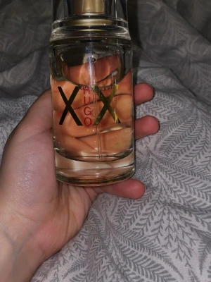 Hugo Boss XX Eau de Toilette 100ml - Fräsch och modern parfym från Hugo Boss, XX Eau de Toilette. Flaskan är genomskinlig med guld- och svartfärgade detaljer samt guldigt lock. Innehåller 100 ml. Perfekt för dig som gillar eleganta och stilrena dofter. För just henne och hennes klassiska stil 