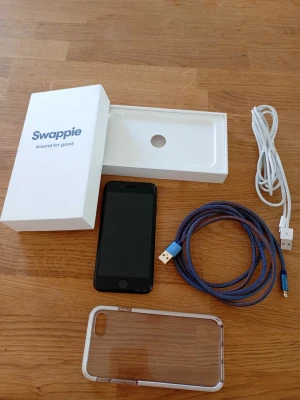 iPhone SE 2020 64GB 97% Olåst - Fungerar utan större skador, 64 GB lagring, TouchID, iOS 26.5. Nytt batteri från Swappie (97%). Fås i Swappies kartong med skal och två trådade laddningskablar. Finns fler skal. Fås utloggad och återställd.  Nu till det tråkiga, tappade den i golvet utan att något gick sönder men skärmen fick sig en stöt och den ser därför ut som på bilderna.llt fungerar fortfarande om än inte optimalt.  Nypris: 5000 SEK Beg pris: 1800 SEK Mitt pris: 689 SEK  Skickas snabbt och spårbart. Fråga! Se  andra annonse