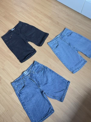 3-pack jeansshorts / baggy shorts S/M - Säljer ett 3-pack snygga jeansshorts i olika washes/färger. Baggy och avslappnad passform som sitter bra till både streetwear och vardag. Storlek S/M. Bra skick och perfekta till sommaren.  * 2 blå denim * 1 svart denim     Säljs tillsammans