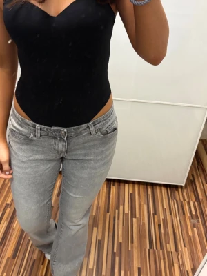 Grå bootcut jeans - Snygga grå jeans med bootcut-modell . De har fem fickor, bälteshällor och dragkedja med knapp framtill. Perfekta för dig som vill ha en avslappnad men trendig stil.