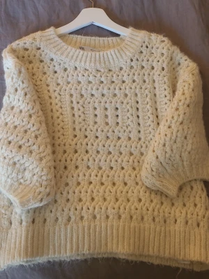 Beige chunky stickad tröja - Beige chunky stickad tröja med grovt hålmönster och bred ribbad kant vid hals, ärmslut och nederkant. Tröjan kommer ifrån Zara och är knappt använd.
