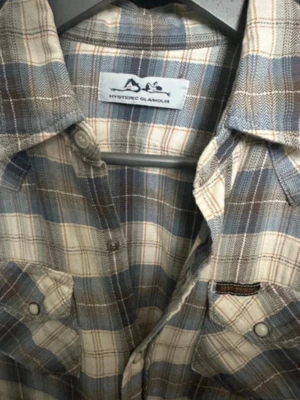 Hysteric Glamour skjorta - Säljer en tvärfet rutig skjorta från Hysteric Glamour i blått, beige och grått. Skjortan har två bröstfickor med knappar, klassisk krage och långa ärmar. Bara att ställa frågor om man har några🤩