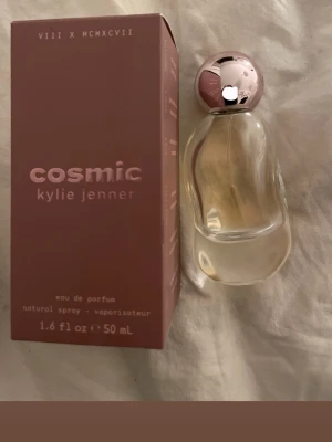 Cosmic parfym från Kylie Jenner - Cosmic eau de parfum från Kylie Jenner i en glasflaska med rund, roséguldig kork. Doften kommer i en snygg rosa kartong och flaskan rymmer 50 ml. Perfekt för dig som gillar trendiga och exklusiva parfymer.