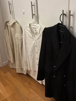 Kläder - Klassisk vit skjorta från Gina Tricot med knappar framtill och krage. Skjortan har lång ärm och är tillverkad i ett mjukt bomullsmaterial. Perfekt att styla till jeans eller kjol för en clean look.