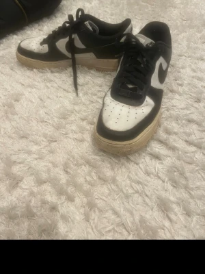 Nike svartvita Air Force 1 sneakers - Säljer ett par klassiska Nike Air Force 1 sneakers i svart och vitt med beige sula. De är i bra skick 