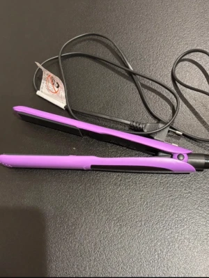 Lila plattång med svart sladd - Säljer en lila plattång med svart sladd och plattor. Plattången har en smal och avlång form, passar perfekt för att styla håret. Enkel att använda med vanlig stickkontakt. Perfekt för dig som vill fixa frisyren snabbt och smidigt.