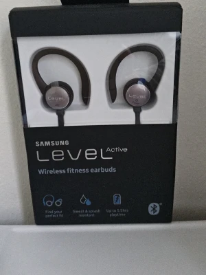 Samsung Level Active trådlösa hörlurar förseglat paket - Säljer ett par svarta Samsung Level Active trådlösa in-ear hörlurar med öronkrokar. Perfekta för träning med svett- och stänkskydd, Bluetooth och upp till 5,5 timmars batteritid. Sitter bekvämt tack vare flera medföljande öronproppar och vingar. Paketet är förseglade vilket bestyrker om att de är helt nya.