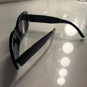 Svarta solglasögon - Snygga svarta solglasögon med rektangulära bågar och mörka glas