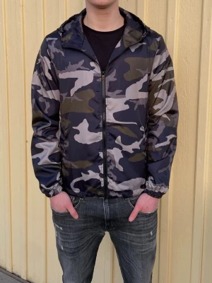Camo windbreaker - Säljer en sprillans ny woolrich liknande camo windbreaker för endast 249 kr. Jackan fungerar perfekt nu inför de kommande vädret och man kan även justera passformen på insidan. Har 4 olika storlekar, XS,S,M och L Hör av er vid minsta fundering.