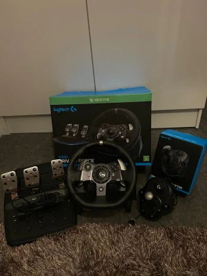 Logitech G920 ratt och pedaler Xbox One - Säljer ett Logitech G920 rattpaket till Xbox/PC i mycket bra skick.  Ingår: - Ratt (Logitech G920) - Pedaler (gas, broms, koppling) - Växelspak (Logitech Driving Force Shifter) - Kablar + originalkartong  Allt fungerar perfekt utan några problem. Väldigt lite använt och väl omhändertaget.  Perfekt för spel som Forza, Assetto Corsa m.fl.  Kan hämtas eller skickas.  Pris: 2500 (prisen är inte fast kan gå ner vid snabb affär)