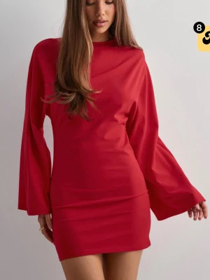 Röd kort klänning med vida ärmar - Trendig röd kort klänning med långa, vida ärmar från Nelly i modellen ”Wide sleeve dress”. Skicket är mycket bra. Storlek XS men skulle nog passa S också 