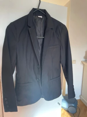 Svart kavaj  - Svart kavaj från Lindex. Nypris 299. I nytt skick endast använd en gång.