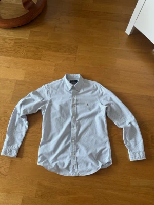 Ralph lauren skjorta - Vårlig Ralph lauren skjorta med ett fint randigt mönster, tveka inte på att höra av er vid frågor.