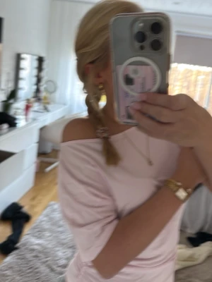 Ljusrosa offshoulder topp - Säljer en ljusrosa offshoulder topp med korta ärmar. Toppen har en tight passform och är tillverkad i ett mjukt, stretchigt material som sitter snyggt på kroppen. Perfekt för dig som gillar en enkel men trendig stil.