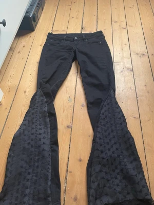 Unika jeans med spets - Lågmidjade svarta jeans som är omsydda till bootcut med svart spets tyg. Midjemått 35 cm och innerbenslängd 76 cm. Kontakta mig gärna privat vid frågor eller liknande💞💞