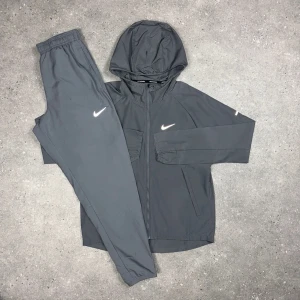Nike Miller Tracksuit - Grå - Nike Miller Tracksuit - Grå • Jacka och byxa i matchande färg • Storlekar från XS till 2XL • Går också att få på activez,se