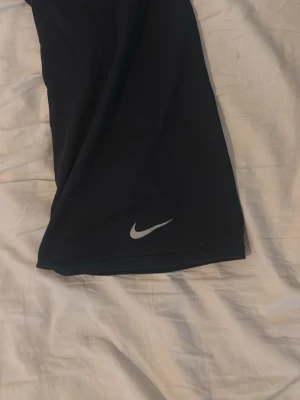 Svarta shorts från Nike - Snygga svarta shorts från Nike med klassisk logga framtill. Perfekta för träning eller chill, tillverkade i mjukt och lätt material som ger skön passform. Enkel design utan extra detaljer för en clean look.