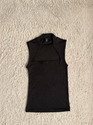 Svart ribbad ärmlös polotopp - Säljer denna skitsnygga  polotopp med ribbad struktur. Nästan som Zara tröjan bara att den är kortärmad istället för långärmad😍 Perfekt att styla med jeans eller kjol för en trendig look.