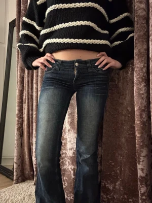 Mörkblå bootcut jeans med slitningar - Snygga mörkblå bootcut jeans, låg midja.