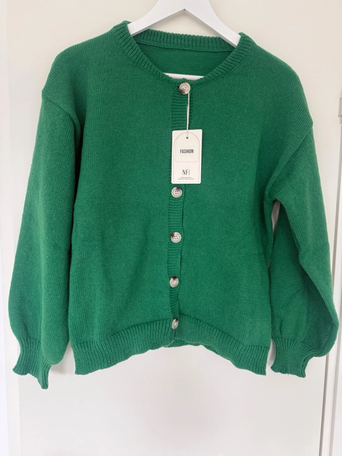 Grön stickad kofta med pärlemorknappar