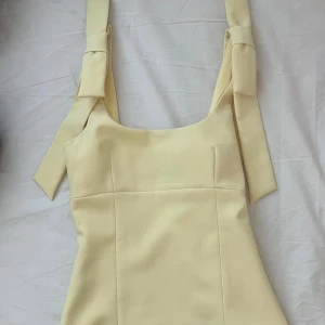 Ljusgul topp med rosetter från Zara - Supersöt ljusgul topp med breda axelband som knyts i stora rosetter på axlarna 💛